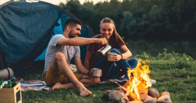 couple camping, drinking coffee by the fire